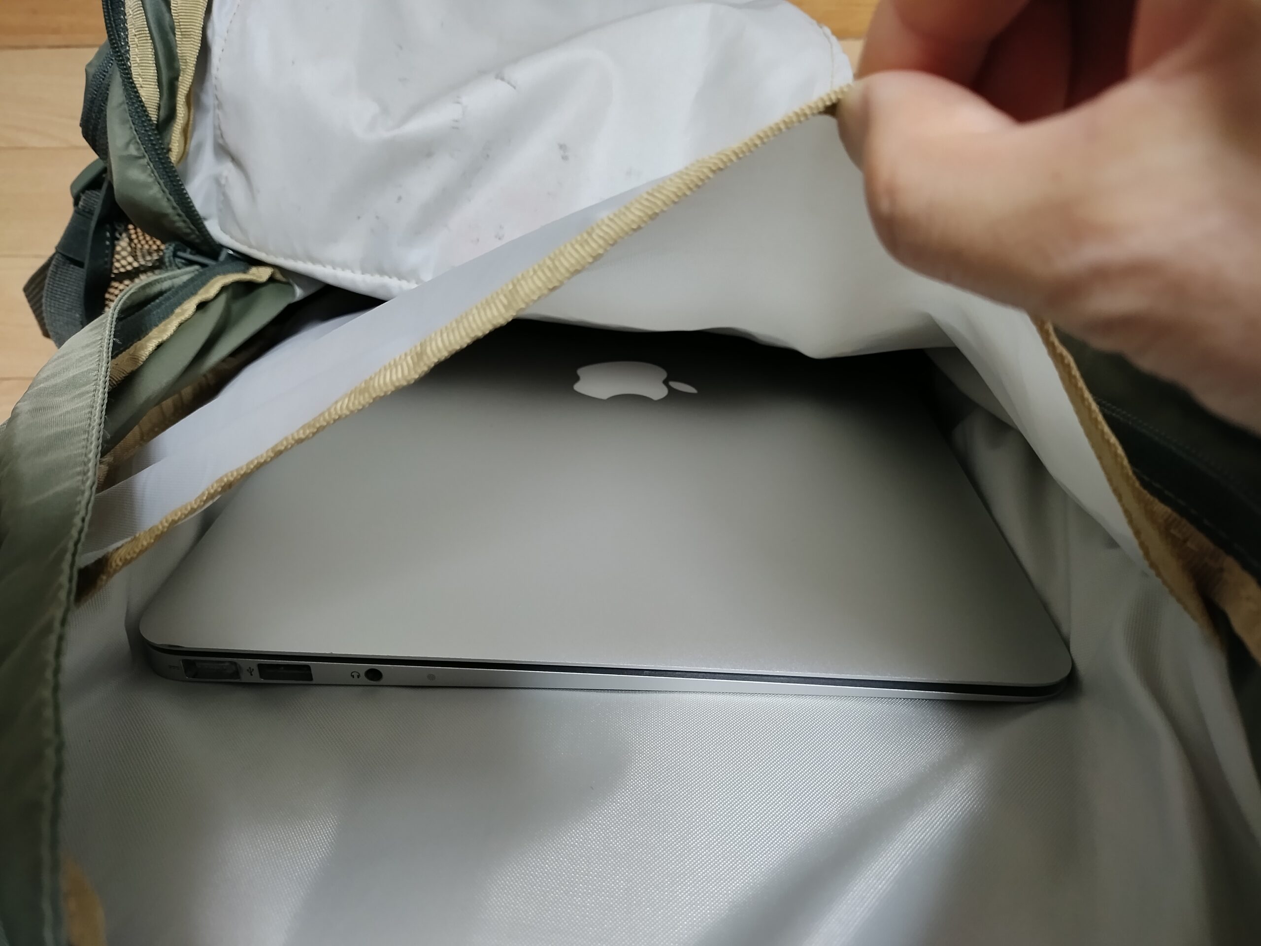 ウォーカー33新モデルのPCポケットにMacBookAir旧型13.3インチをそのまま入れて、ポケットの薄い生地を指でつまんでいる写真